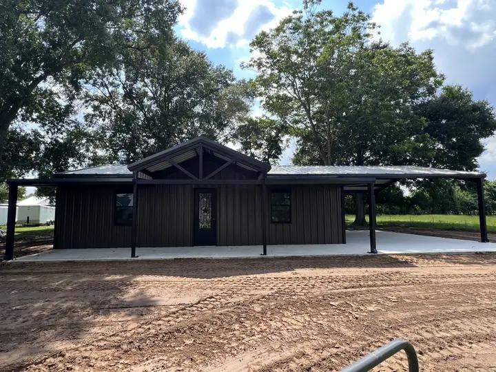Black barndominium with a full front porch