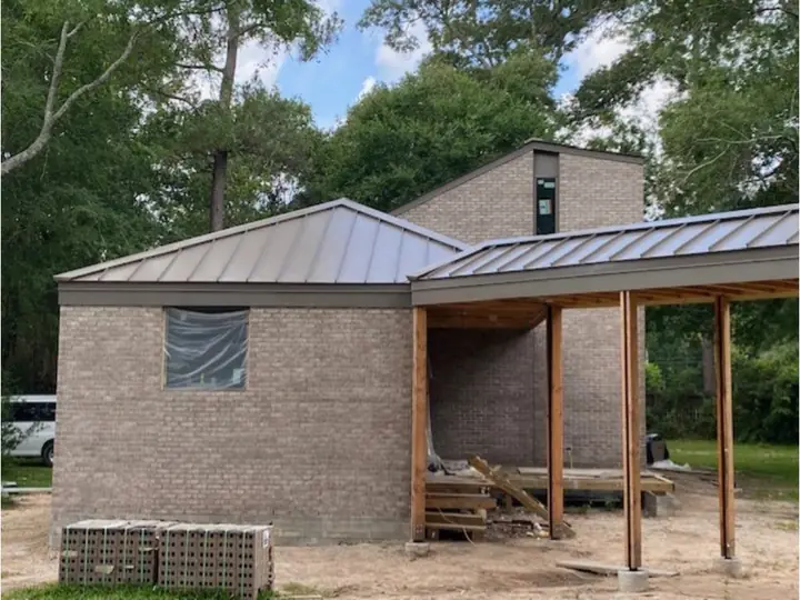 Brick home with a metal roof and covered porch