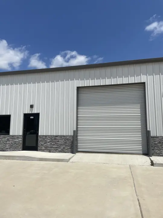 Commercial unit with roll-up door and stone wainscot