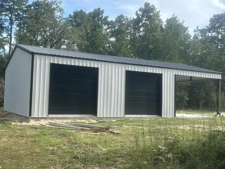 Gray building with lean-to and black doors