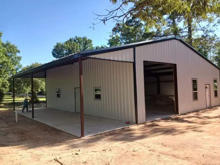 Tan barn with an open bay and lean-to