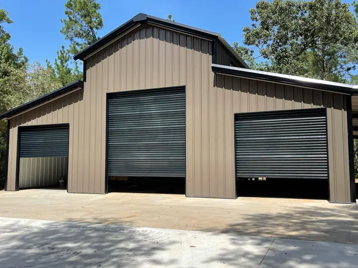 Tan barn-style building with black roll-up doors
