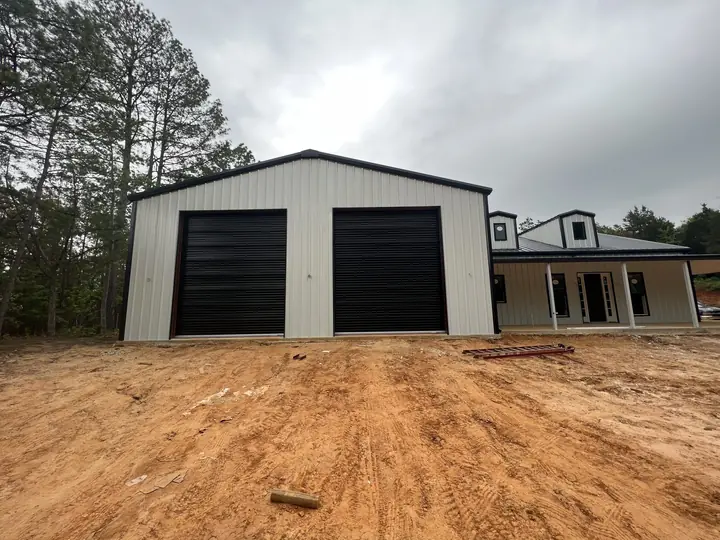 Two-bay garage with black roll-up doors